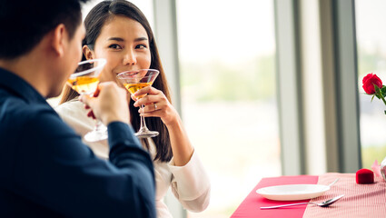 Romantic young happy couple relax talking and drinking wine glasses celebrate together in the restaurant