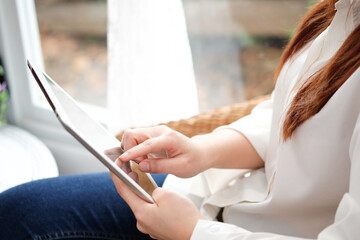 Fototapeta premium women modern lifestyle she sat in the living room on sofa , using his tablet pc online To buy product in the internet