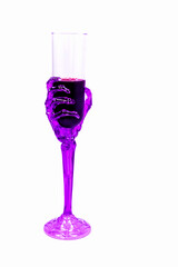 Cool wine glass (with a transparent purple skeleton of the wrist and hand making up the shaft and grip bowl) filled with blood or wine. Halloween party celebration concept.