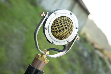 Old school round voice microphone photographed outside