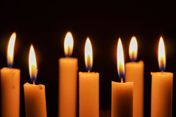 Close up photo of group candlelight in the dark, close up of burning candles in the dark.