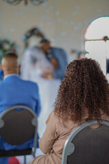 Blurred background of groom kissing bride during ceremony