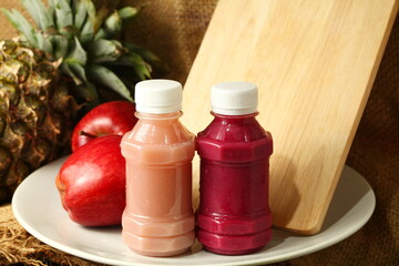 Fruit juice bottle among fruit scene.