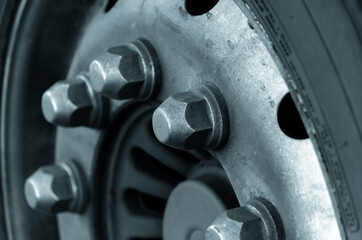 A close-up of a classic tractor wheel with chrome nuts.