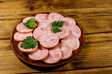 Ham sausage on a plate on wooden table