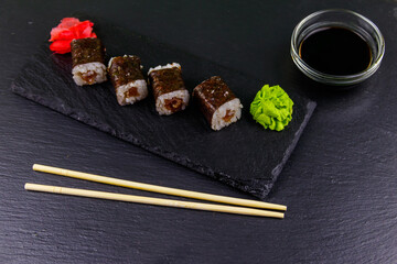 Sushi maki rolls with tuna on black slate