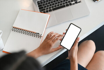 Cropped shot of bussinesswoman using smart phone whith white screen on her working space.