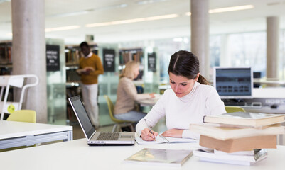 Fototapeta na wymiar Successful woman studying in the library. High quality photo