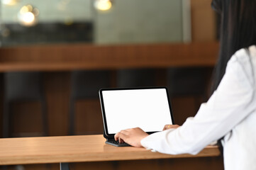 Cropped shot of businesswoman hands typing on computer tablet while working on office desk.