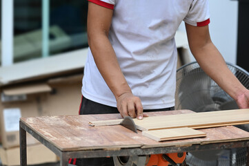 Cropped shot of carpenter working with equipment on wooden table in carpentry shop.