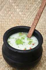 Spiced buttermilk / chaas / chaach / moru / sambharam / curd, lassi, yogurt, cool refreshing drink for hot summer in a clay pot, Kerala, India. Flavored Indian buttermilk.