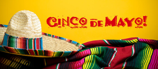 Mexican Serape blanket and sombrero on yellow background with Cinco de Mayo.  - 381550959