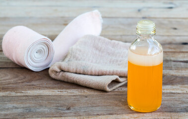 first aid with herbal oil medication liniment and bandage health care pains and aches for athlete decoration on background wooden