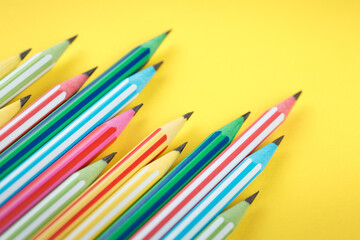 multicolored pencils on yellow isolated background