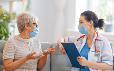 Doctor and senior woman wearing facemasks