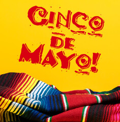 Mexican Serape blanket on yellow background with Cinco de Mayo. 