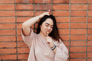 Asian chubby woman enjoy eating lollipop candy.