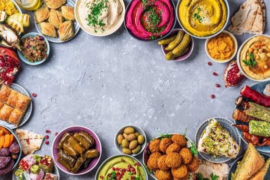 Arabic traditional cuisine. Middle Eastern meze with pita, olives, colorful hummus, falafel, stuffed dolma, babaganush, pickles, vegetables, pomegranate, eggplants. Mediterranean appetizer party idea