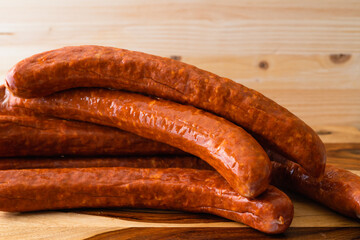 Smoked pork sausages close up on wooden background