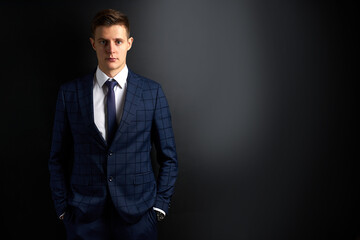 portrait of serious handsome male in trendy classic suit, isolated on black background. young successful guy entrepreneur posing