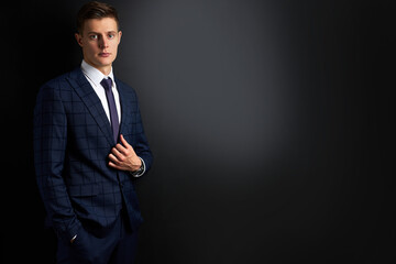 attractive caucasian man in formal stylish suit posing at camera isolated on black background, confident business person