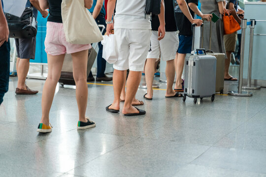 Queue of Asian people waiting at boarding gate at airport. Close-up composition