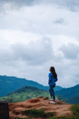 Fototapeta premium Rear view image of female traveler looking at a beautiful green mountains view