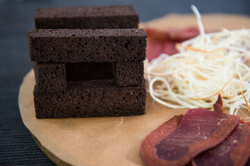 On the paper is smoked sausage and cheese in small threads. Close-up, background.