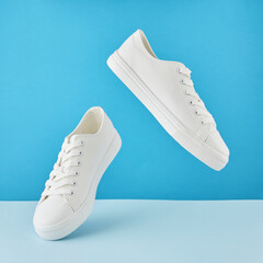 Pair of fashion stylish white sneakers, Running sports shoes on pastel blue background.