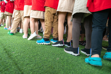 Obraz premium Queue of Asian kids in school uniform standing in line