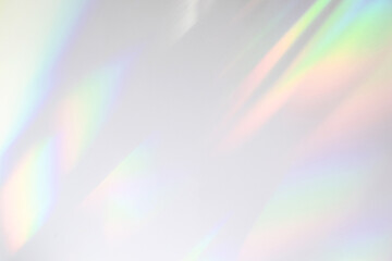 Blurred rainbow light refraction texture overlay effect for photo and mockups. Organic drop diagonal holographic flare on a white wall. Shadows for natural light effects - 381556951