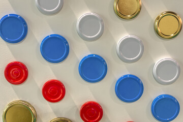 Multi-colored metal lids for glass jars.