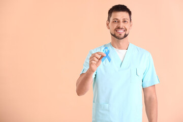 Doctor with blue ribbon on color background. Diabetes awareness concept