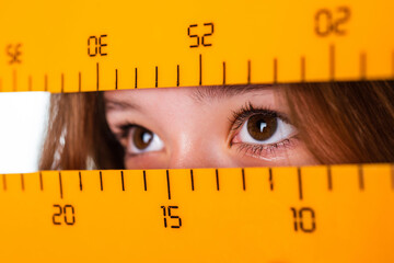 Cute teen child near chalkboard with math tool ruler, back to school