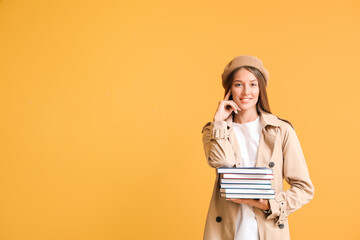 Beautiful young woman with books on color background