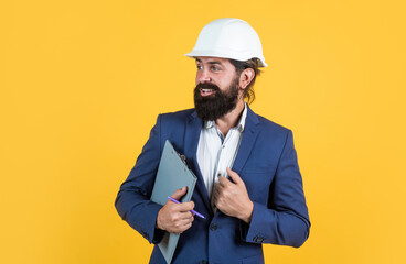architecture and building. male builder wearing formal suit and helmet for protection. working on...