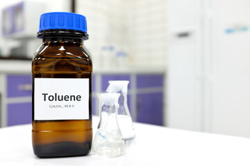 Selective focus of toluene liquid chemical compound in dark glass bottle inside a chemistry laboratory with copy space. Aromatic hydrocarbon used in petrochemical industry.