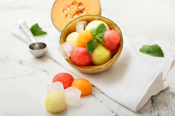 Tasty melon balls with ice on white background