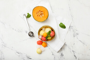 Tasty melon balls with ice on white background