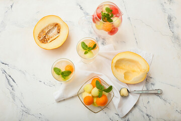Tasty melon balls with cold cocktail on white background