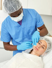 Portrait of woman client and doctor during beauty facial injections in medical esthetic office