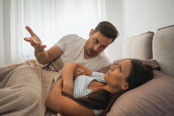 Young couple is arguing in bed.