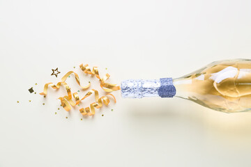 Bottle of champagne and glitters on white background. New year celebration © Pixel-Shot