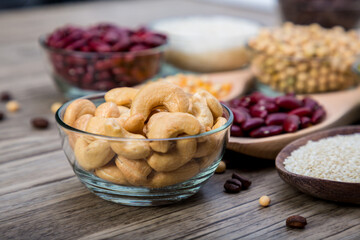 Tasty cashew nuts in bowl on wooden table. Bowl with cashew nuts on wooden table. Roasted cashew nuts 