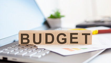 BUDGET Wooden cubes with letters on a laptop keyboard.