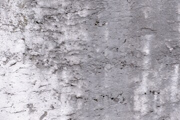 A very weak white sand wall with several cracks and holes grey in color