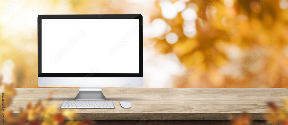 Aufkleber autumn background.blank desktop computer on rustic wood table with blur forest tree with sunlight,au