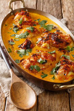 Kenyan chicken in coconut curry sauce Kuku Paka Recipe closeup on the table. Vertical