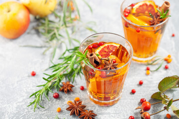 Winter or autumn hot healing tea with pear, orange, lingonberries, sea buckthorn and spices in...