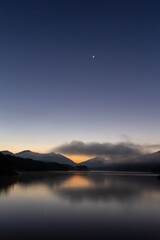 雲と星が美しい夜明けの湖